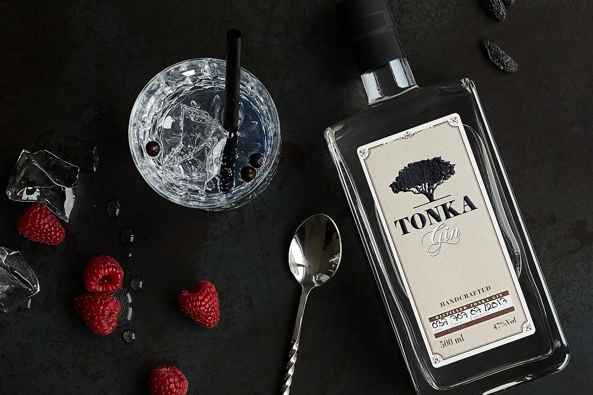 Tonka Gin - Klassik - Flaschenfront mit Glas und frischen Himbeeren